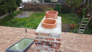 New crown poured on top of a chimney, has new flue tiles embedded in the crown.