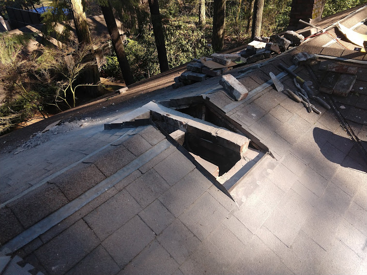 Chimney torn down just below the roof, exposing roof flashing.