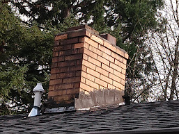 Tar smeared upon chimney flashing.